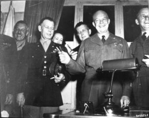 Supreme Commander of the Allied Expeditionary Forces, General Dwight D. Eisenhower holds up the pens used to sign the first unconditional Nazi surrender in Reims, France on May 7, 1945. (Source: Museum of the Surrender, CC BY-SA 4.0, G. Garitan)